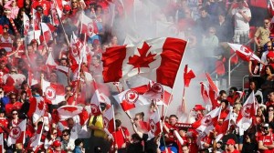 Spectators wave flags as Canada and the U.S. play during the second half of their friendly women's soccer match in Toronto, June 2, 2013. (MARK BLINCH/REUTERS)