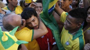 A Brazilian fan, left, consoles a Chilean fan after Brazil defeated Chile on a World Cup round of 16 soccer match in Belo Horizonte, Brazil, Saturday, June 28, 2014. (Victor R. Caivano/AP)